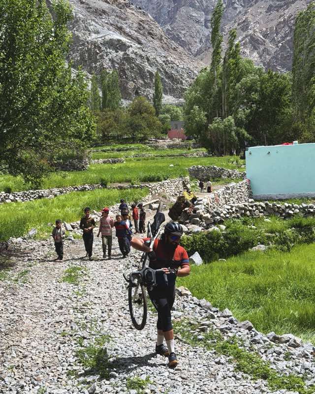 A rider surrounded by smiling village kids