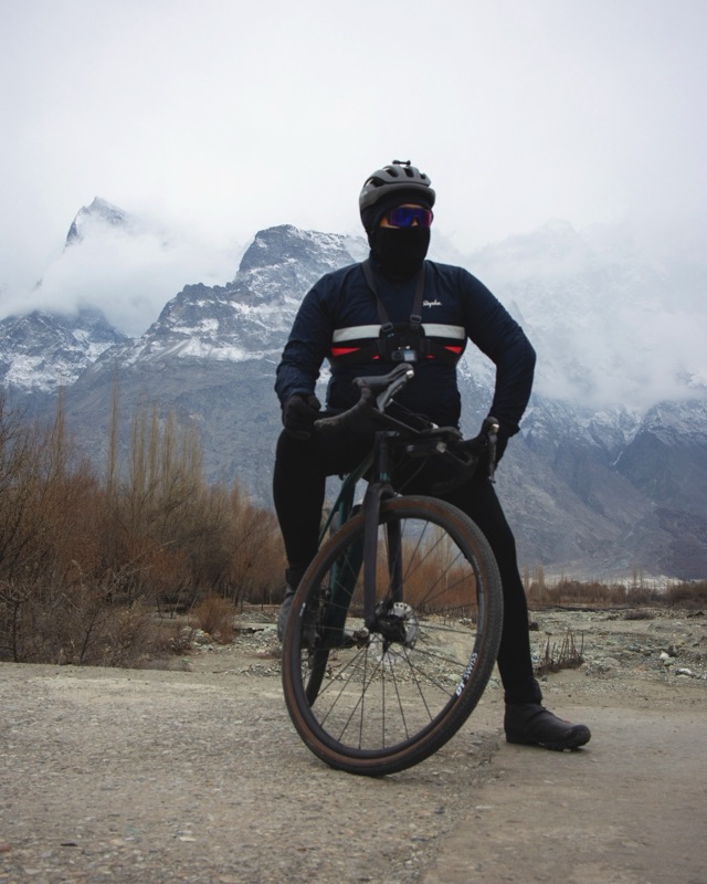 A rider in Shigar with snow-dusted peaks behind