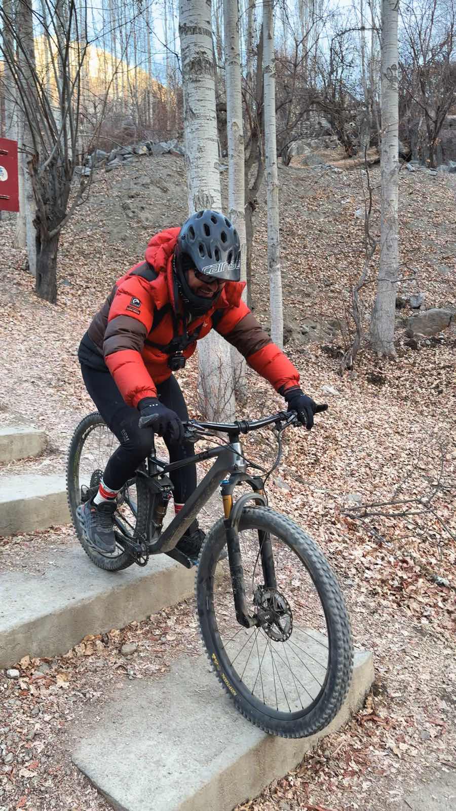 Hassnain carrying a bike down the stairs to Upper Kachura lake