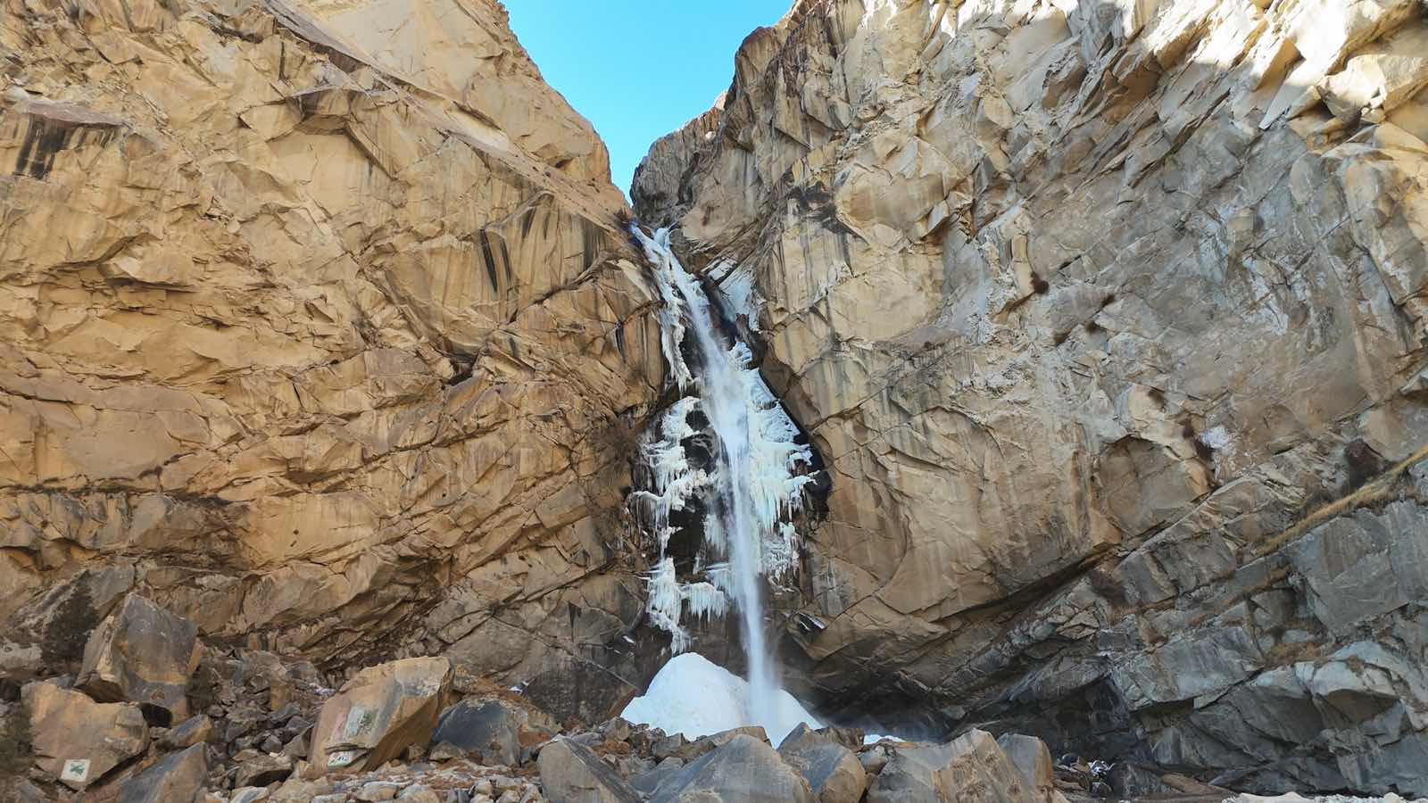 Khamosh waterfall part-frozen between rock walls